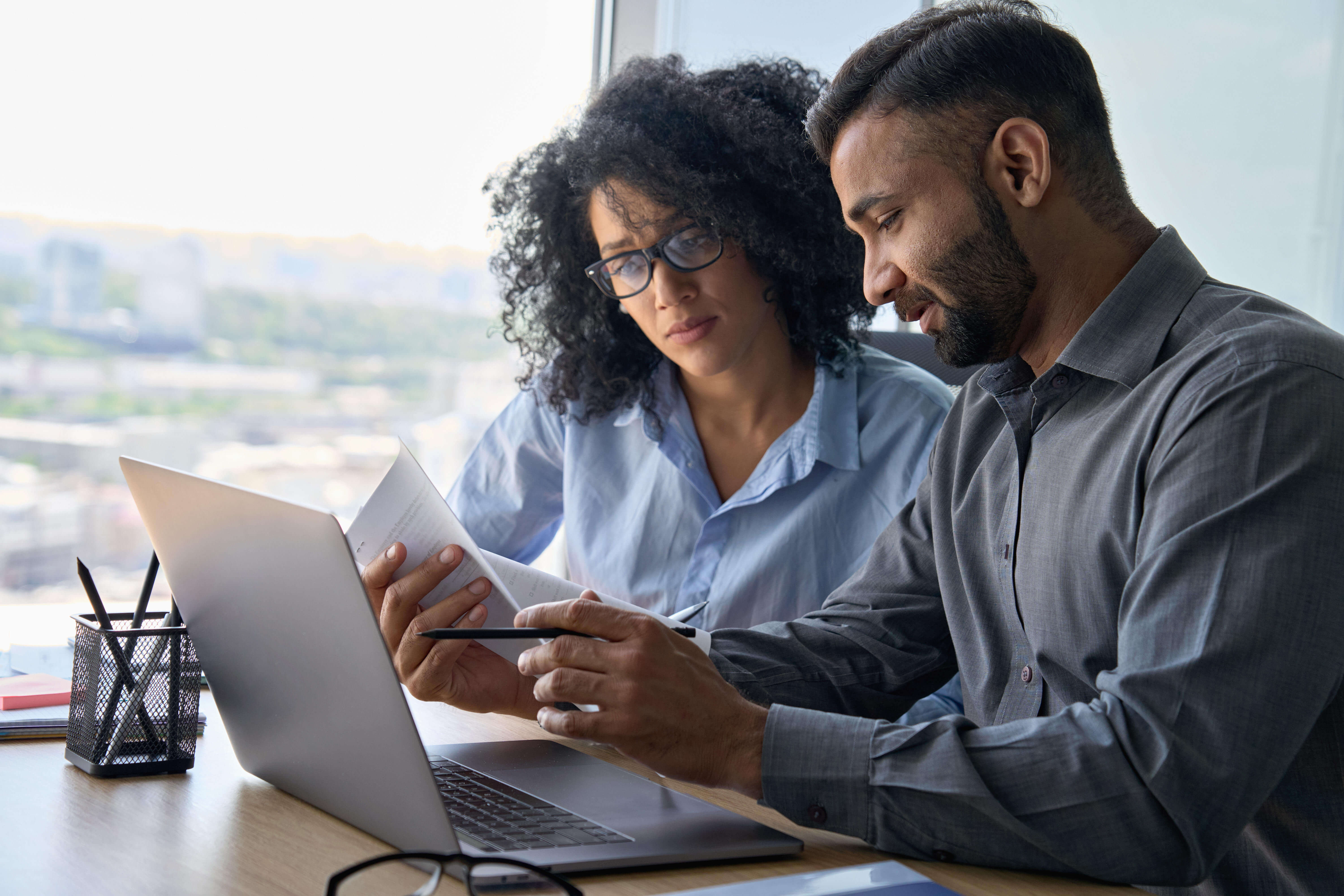 Pair of financial service workers looking at benefits of AMLHUB